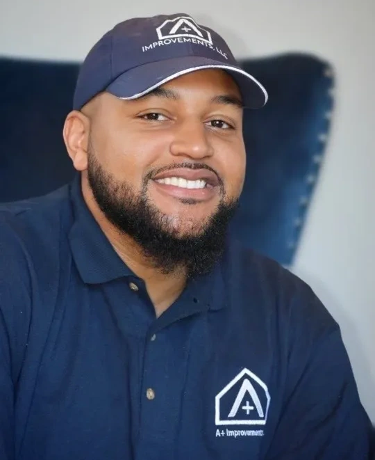 rs=w_1440,h_1440 (4) (1) Smiling man wearing a navy blue shirt and cap with a logo, posing indoors against a blurred background.